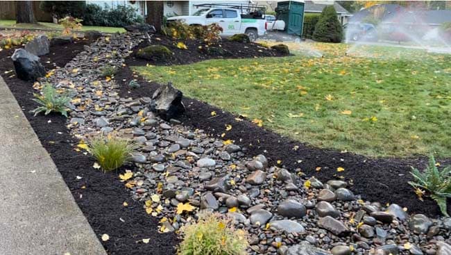 Riprap armoring and native revegetation on a stabilized slope after grading correction