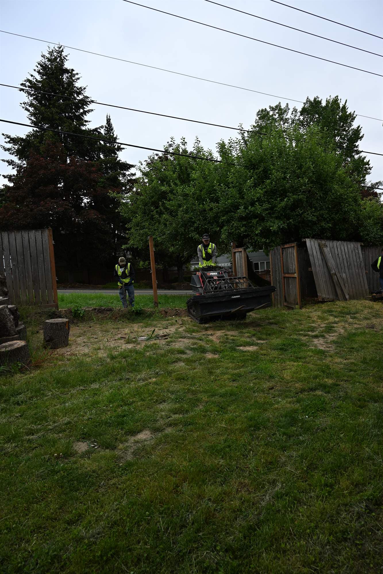 Cleared and rough-graded backyard job site prepared for drainage correction and replanting