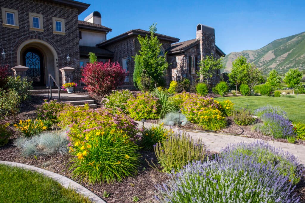 Luxury home with vibrant garden, custom landscaping, and scenic backdrop Luxury home with vibrant garden, custom landscaping, and scenic backdrop