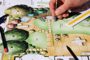 Designer sketching a professional garden layout with trees and seating areas Designer sketching a professional garden layout with trees and seating areas