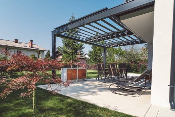 Newly built modern patio with pergola, seating area, and outdoor greenery Newly built modern patio with pergola, seating area, and outdoor greenery