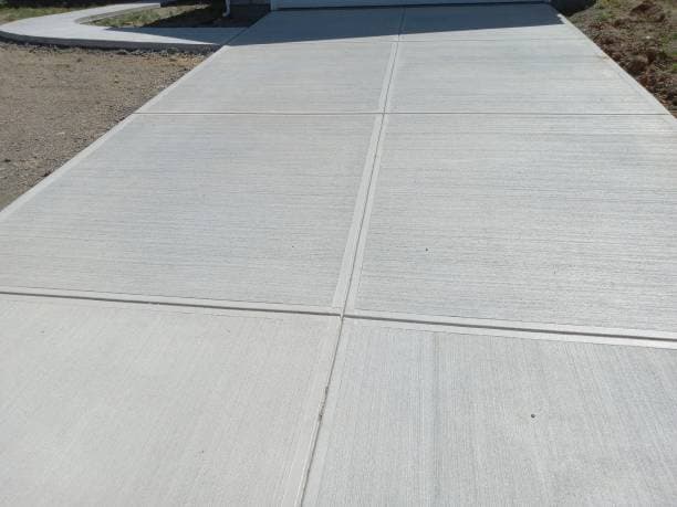 Newly installed concrete driveway with a smooth and durable finish Newly installed concrete driveway with a smooth and durable finish