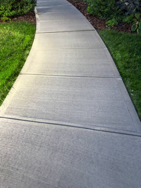 Freshly installed concrete walkway with a smooth and clean finish Freshly installed concrete walkway with a smooth and clean finish