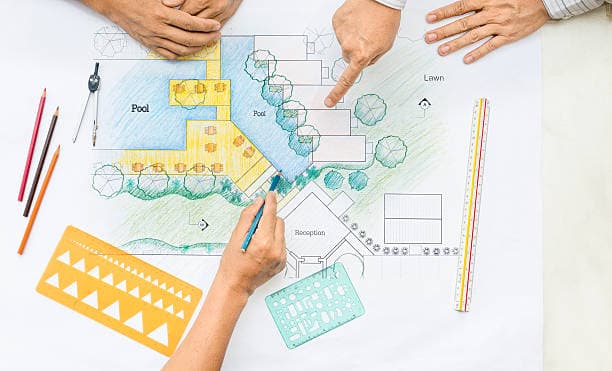 Landscape architects discussing garden and pool layout in a master plan design Landscape architects discussing garden and pool layout in a master plan design