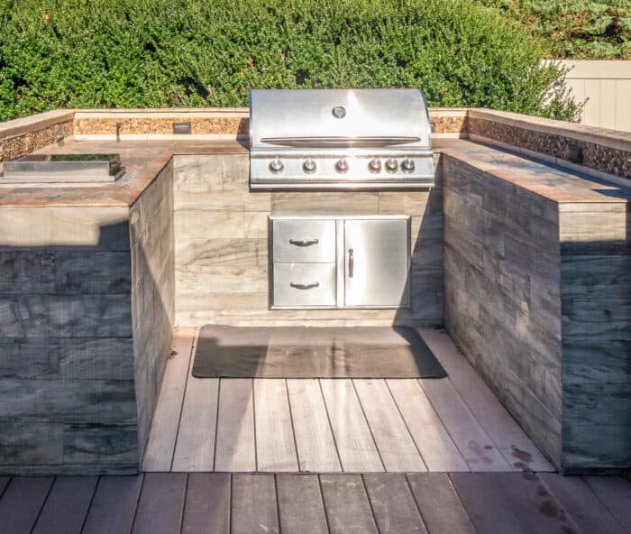 Built-in outdoor kitchen grill with stone finish and prep counters Built-in outdoor kitchen grill with stone finish and prep counters