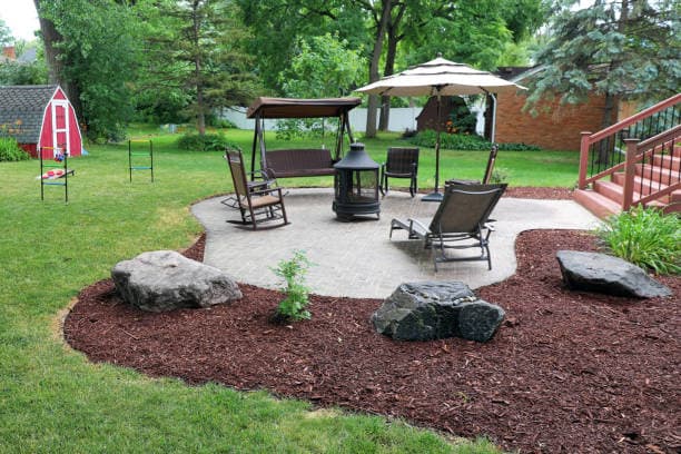 Beautifully designed concrete patio with seating and landscaping accents Beautifully designed concrete patio with seating and landscaping accents