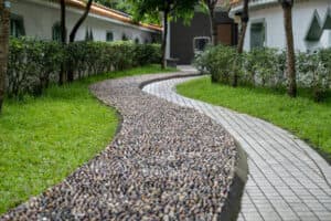 Curved gravel path in a garden surrounded by greenery and shrubs Curved gravel path in a garden surrounded by greenery and shrubs