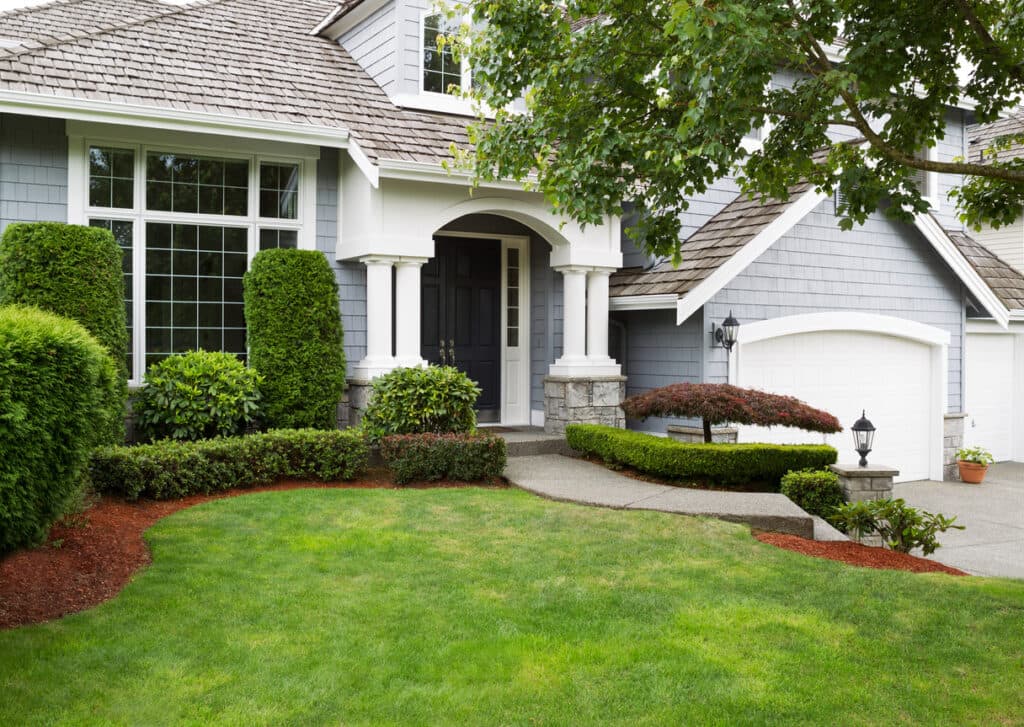 Front yard with manicured lawn, shrubs, and newly installed landscape Front yard with manicured lawn, shrubs, and newly installed landscape