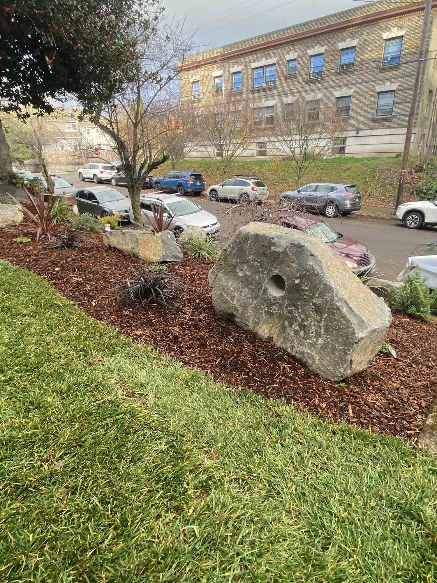 Freshly mulched bed with boulder accents after a spring clean-up and edging pass