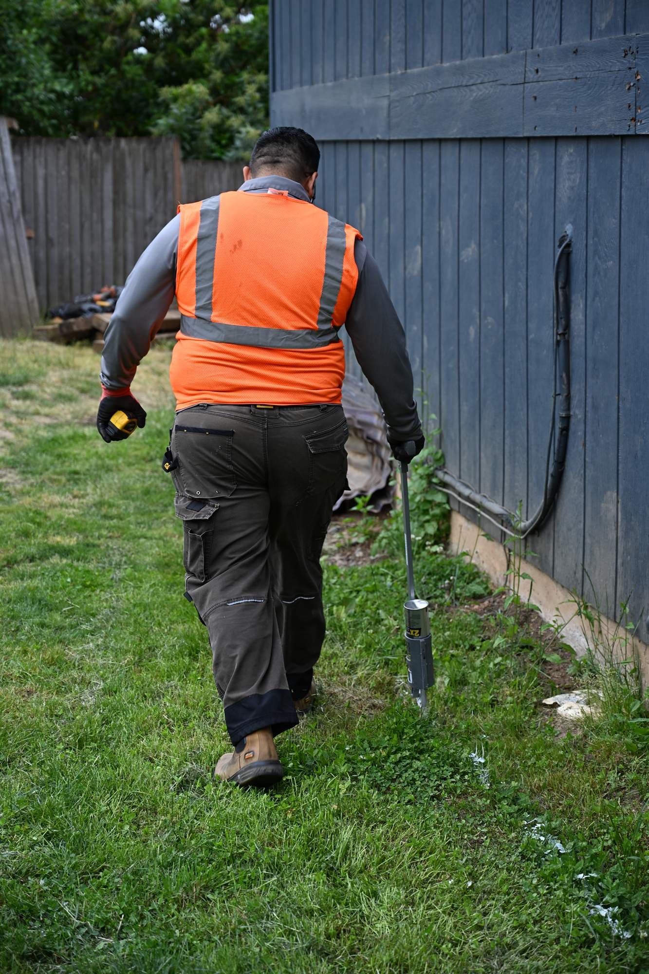 OCL crew member clearing clippings from a freshly serviced lawn with a backpack blower