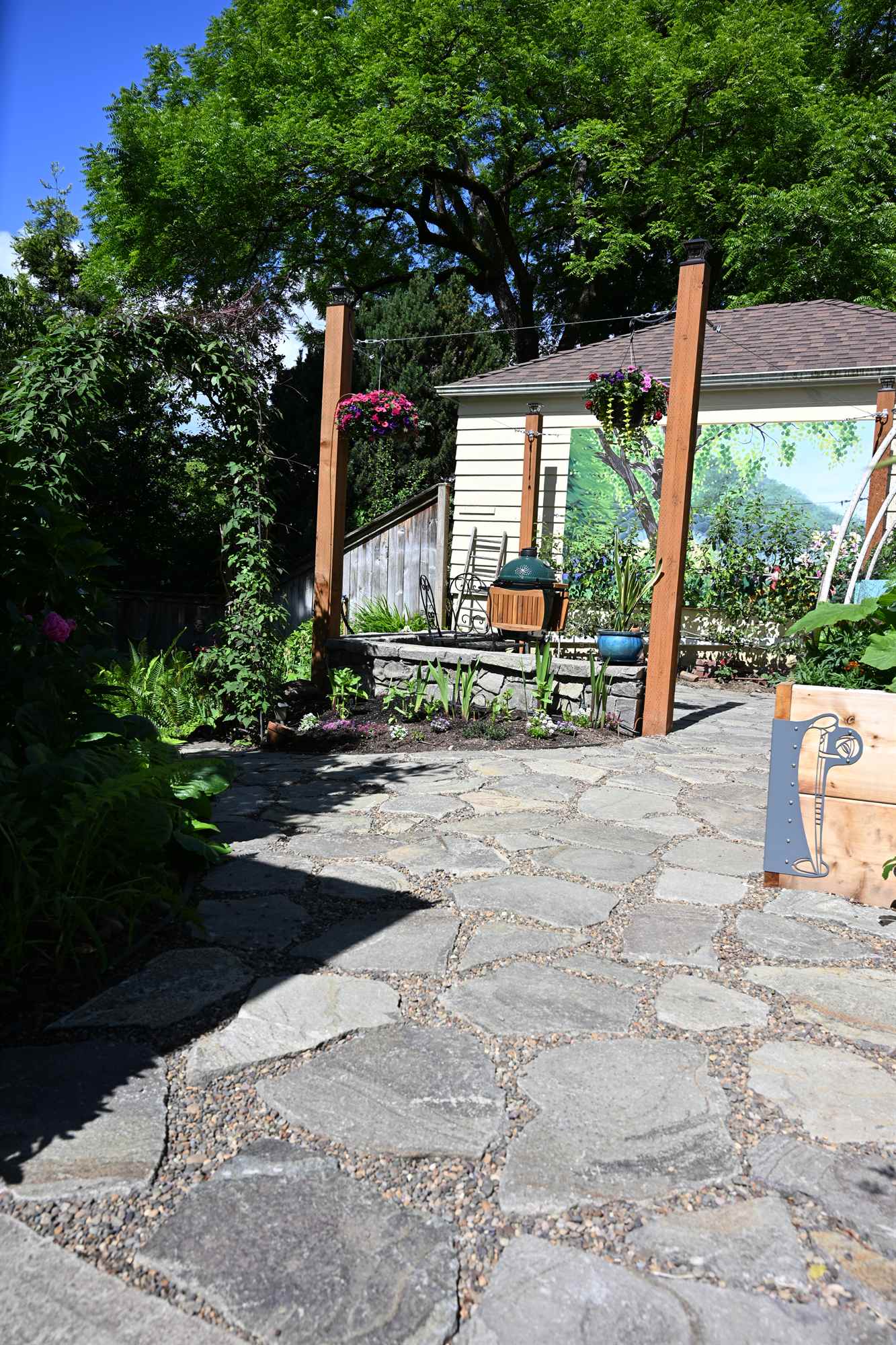 Flagstone pathway winding through custom garden beds
