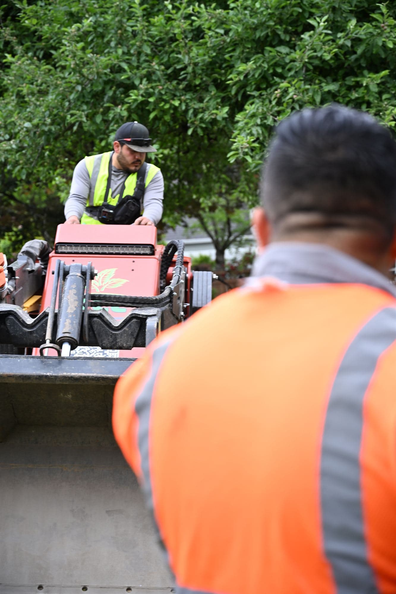 OCL operator regrading a residential slope with a compact loader for proper drainage